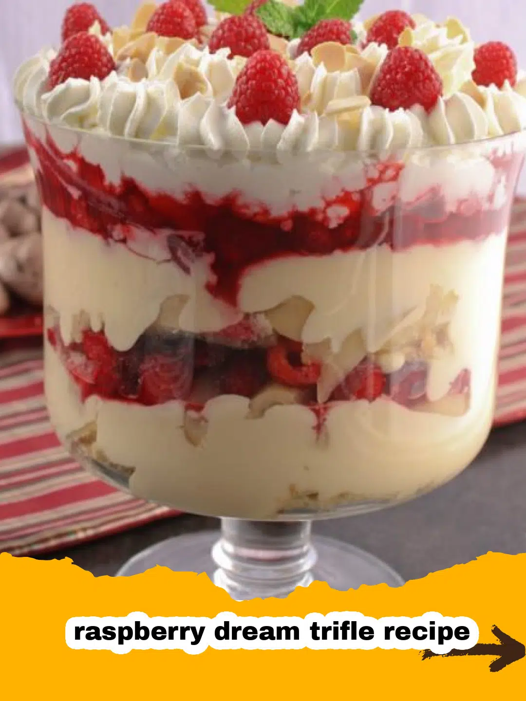 Layering Raspberry Dream Trifle with Pound Cake Close-up of a trifle bowl being layered with golden pound cake cubes for a raspberry dream trifle.